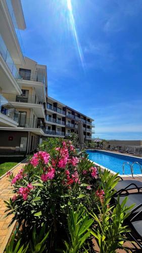 a large apartment building with a pool and pink flowers at Casa Montenegro 1 Plus 1 Suite View Sea and Pool in Kavač