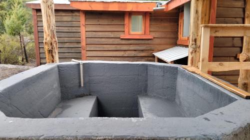 a concrete tub in front of a house at Refugio entre Coihues in Melipeuco