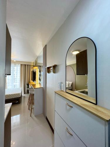 a bathroom with a sink and a mirror at Cloud Nine Poolview Condo Near Mactan Airport in Suba
