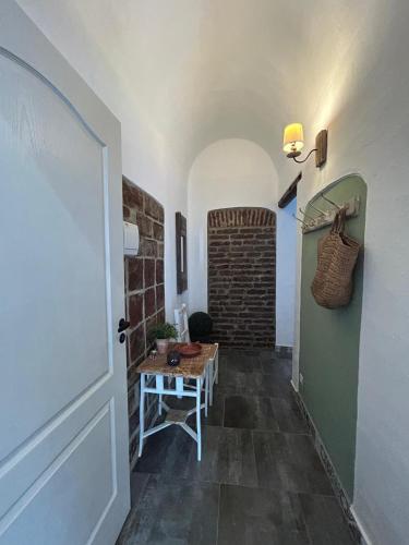 a hallway with a table and a brick wall at Pé na Terra Quintal in Reguengos de Monsaraz