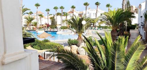 an overhead view of a resort pool with palm trees at APARTAMENTO LUXURY Golf Center in Roquetas de Mar