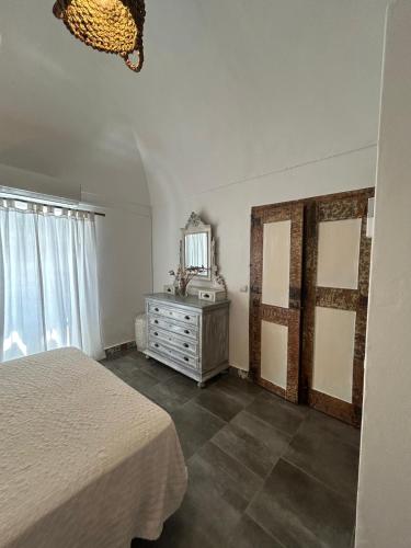 a bedroom with a bed and a dresser and a mirror at Pé na Terra Quintal in Reguengos de Monsaraz