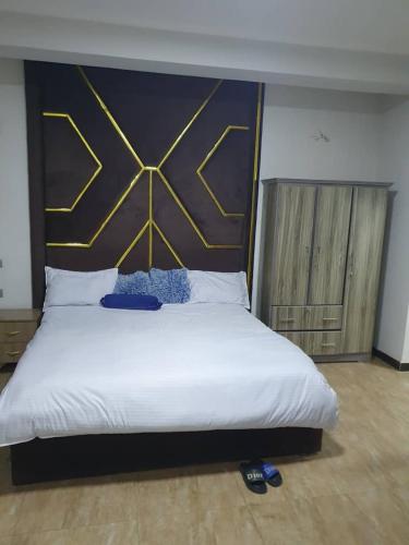 a bedroom with a large bed with a large headboard at Revo guest house in Addis Ababa