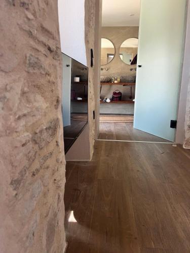 a hallway with a stone wall and wooden floors at Nymfea Ano Syros in Ano Syros