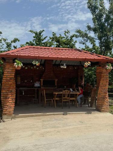 Un pabellón de ladrillo con una mesa y sillas. en Tatia's guesthouse, en Zugdidi