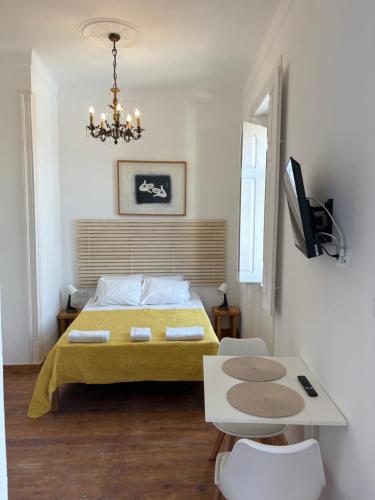 a bedroom with a bed and a table and a television at Sea the City Setúbal in Setúbal
