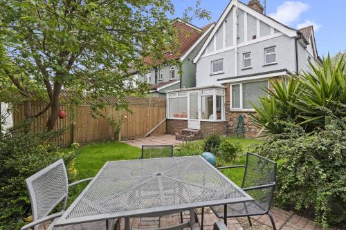 a patio with a table and chairs in front of a house at Pebble Corner with Free Parking By My Getaways in Worthing