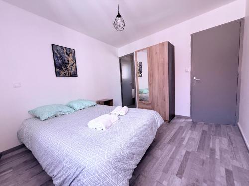 ein Schlafzimmer mit einem Bett mit zwei Handtüchern darauf in der Unterkunft Appartement Cosy Auxerre centre ville Arrivée autonome in Auxerre