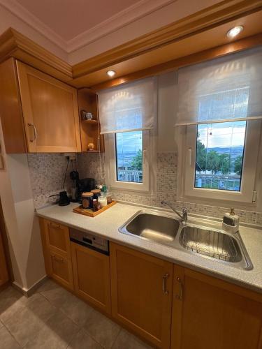 una cocina con fregadero y ventana en Neraida view, en Neráïdha