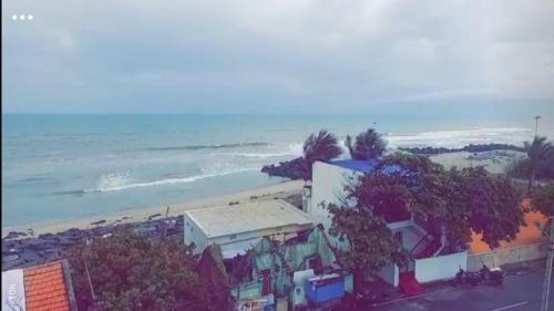una vista dall'alto di una spiaggia con un edificio e alberi di Ramesh home stay nearby Py Rock beach a Pondicherry