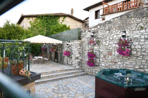 a stone building with a hot tub in a courtyard at Sokaku Monark in Berat