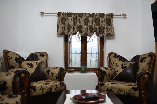 a living room with two chairs and a window at Sokaku Monark in Berat