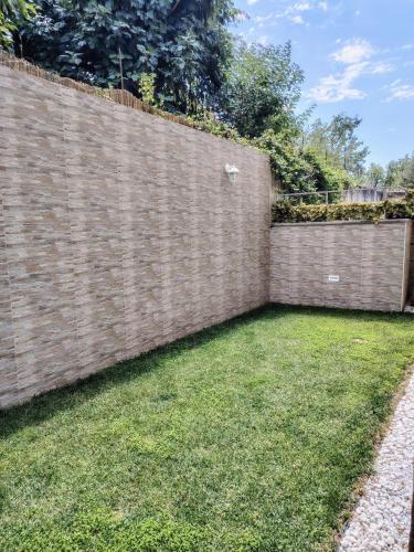 a brick fence with a lawn in front of it at Vivere in Slovenia in Plavje