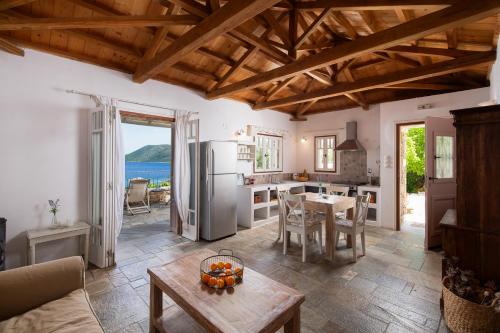 a living room with a kitchen and a table at Lithea Villas and Studios by the Sea in Aghios Petros Alonissos