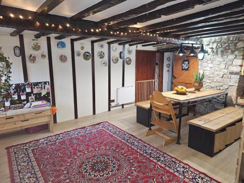 - un salon avec une table et un tapis dans l'établissement Quirky&Old Cottage for Families, à Colyford