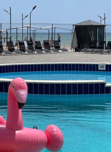 a pink float in a pool next to a swimming pool at Коттедж Атлантис in Chon-Sary-Oy