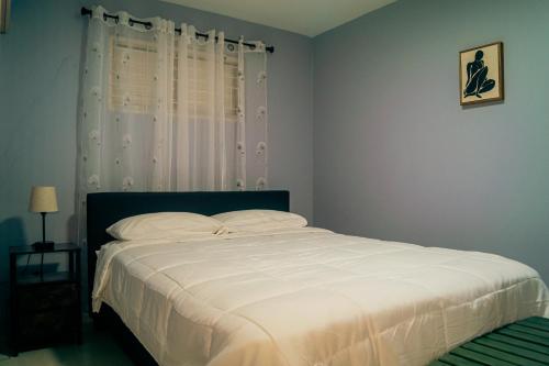 a bedroom with a bed with white sheets and a window at 2,3 or 4 Bd townhouse overlooking Kingston in Kingston