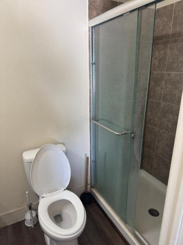 a bathroom with a toilet and a glass shower at Jackson Inn in El Campo