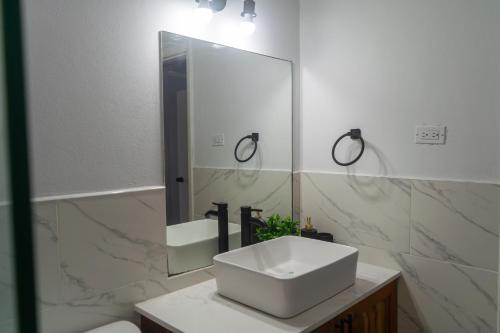 a white bathroom with a sink and a mirror at 2,3 or 4 Bd townhouse overlooking Kingston in Kingston