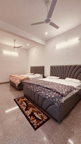 a bedroom with two beds and a ceiling at J Terminal Hotel & Cafe in Barkot