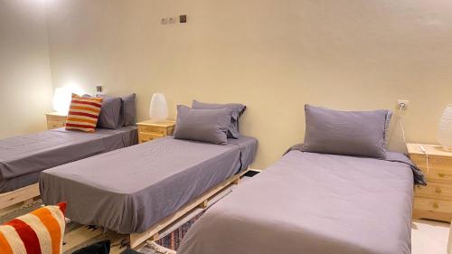 a room with three beds in a room at Beach House Douira in Agadir