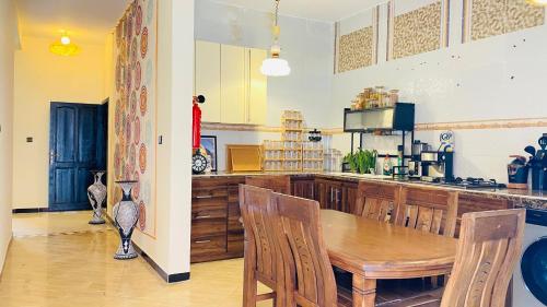 a dining room with a table and a kitchen at Beach House Douira in Agadir
