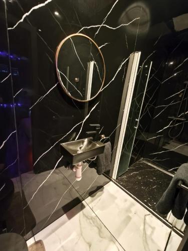 a bathroom with a sink and a mirror at Suite love Jacuzzi in Charleroi