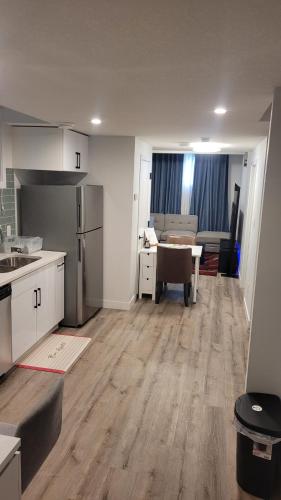 an empty kitchen and living room with a table and a kitchen at Newly Built Private Basement Suite in Prescott in Spruce Grove