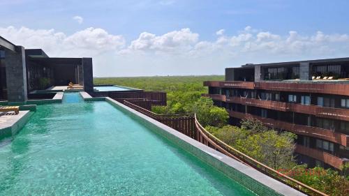 a swimming pool on the side of a building at Hotel zone - Private Jacuzzi & Free Beach Club in Tulum