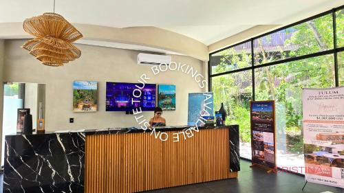a woman sitting at a counter in a store at Hotel zone - Private Jacuzzi & Free Beach Club in Tulum