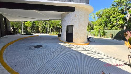 a pavilion with a building with a stone pillar at Hotel zone - Private Jacuzzi & Free Beach Club in Tulum