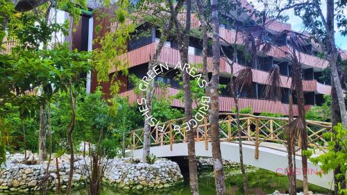 a bridge over a river in front of a building at Hotel zone - Private Jacuzzi & Free Beach Club in Tulum