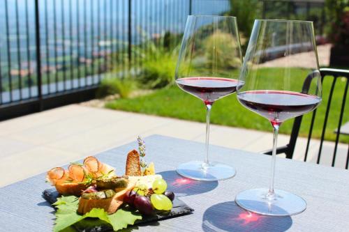 two glasses of wine sitting on a table with food at Hillepranter in Marlengo