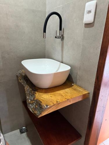 a bathroom with a white sink on a wooden table at Chalé das Dunas Guajiru in Trairi