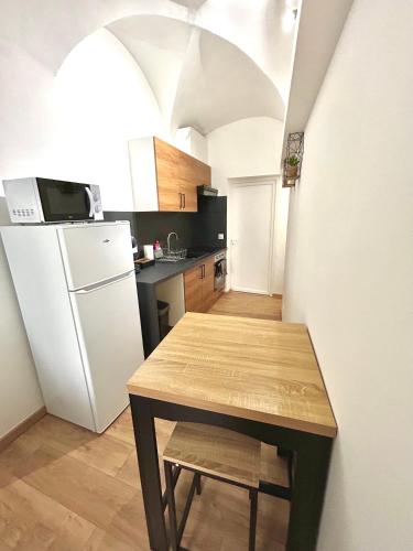une cuisine avec une table et un réfrigérateur blanc dans l'établissement Studio en RDC atypique, à Draguignan