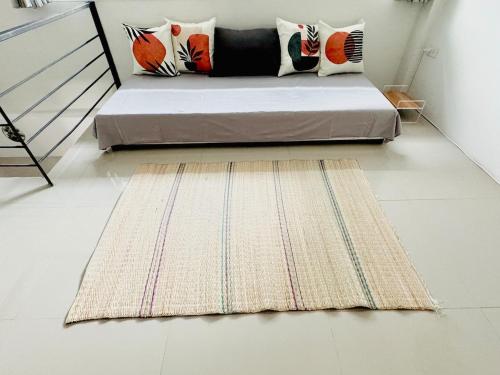 a bed in a room with a rug on the floor at Mandala loft close to the beach in Haad Chao Phao
