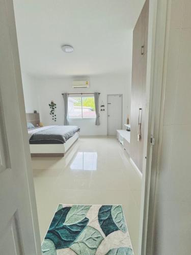 a bedroom with a bed and a rug on the floor at Mandala loft close to the beach in Haad Chao Phao