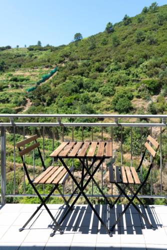 a picnic table and chairs on a balcony with a mountain at Le Terrazze di katia rooms in Riomaggiore