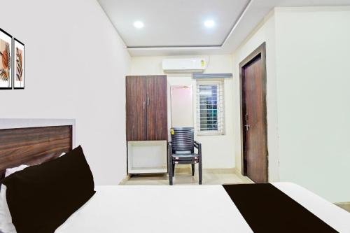 a bedroom with a bed and a chair at Hotel O Mayur Inn in Surūrnagar