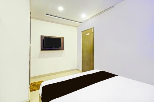 a bedroom with a bed and a tv on the wall at Hotel O Mayur Inn in Surūrnagar