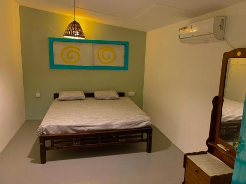 a small bedroom with a bed and a mirror at Sun Rock Villa Arugambay in Arugam Bay