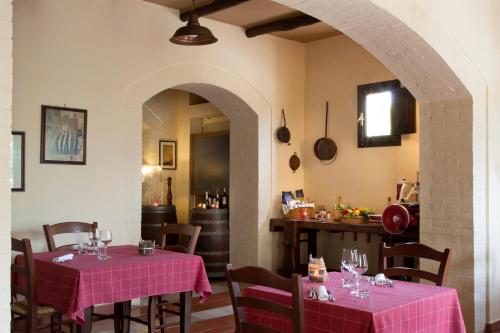 a dining room with two tables with pink table cloth at Il Granaio dei Casabella in Paestum