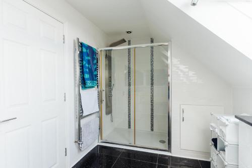 a bathroom with a shower with a glass door at Lyndale House - North Norwich suburbs in Norwich