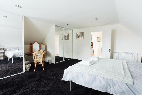 a white bedroom with a bed and a mirror at Lyndale House - North Norwich suburbs in Norwich