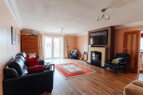 a living room with a couch and a fireplace at Lyndale House - North Norwich suburbs in Norwich
