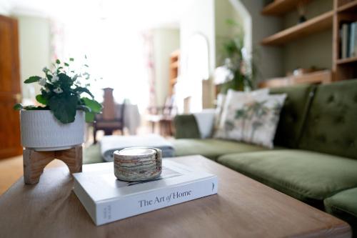 a living room with a table with a candle on a book at Stratford Green House in London