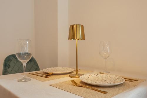 a table with two glasses and plates and a lamp at *NEW IN 2025* - Hotel Subra Atrium in Herceg-Novi