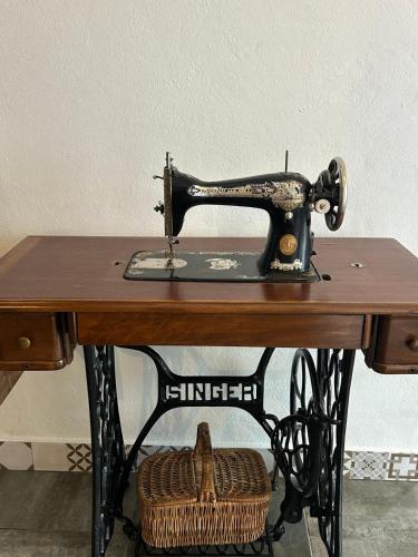 an old sewing machine sitting on top of a wooden table at Pé na Terra Quintal in Reguengos de Monsaraz