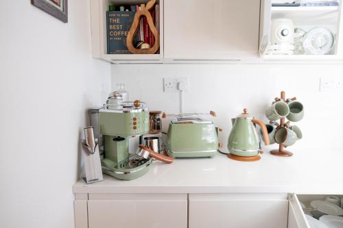 a kitchen with green appliances on a counter at Stratford Green House, London - Cosy Home, Sleeps 5 in London