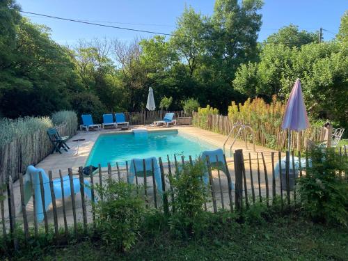 - une piscine dans une cour avec des chaises et des parasols dans l'établissement Villa, vieille ferme rénovée calme, nature avec piscine privée., à Vindrac-Alayrac